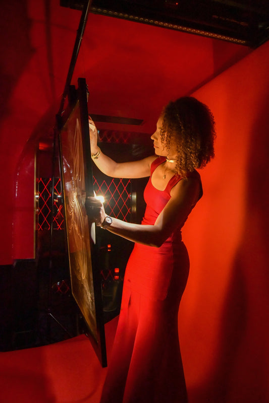 Marie De Decker réalisant la performance Variations sur une surface de verre dorée au Castel Paris.